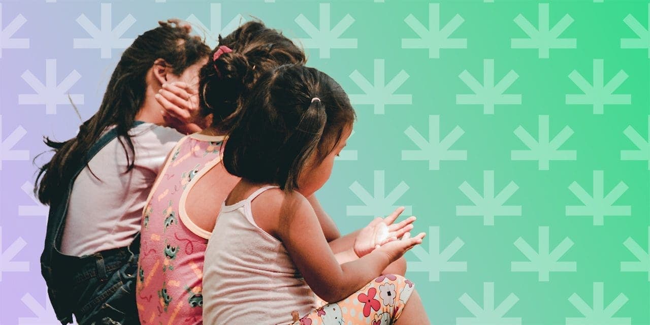 three kids, girls on their backs sitting close to each other